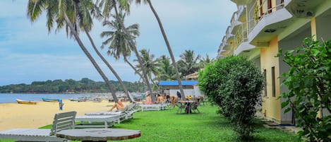 En la playa, sillas reclinables de playa, sombrillas, toallas de playa
