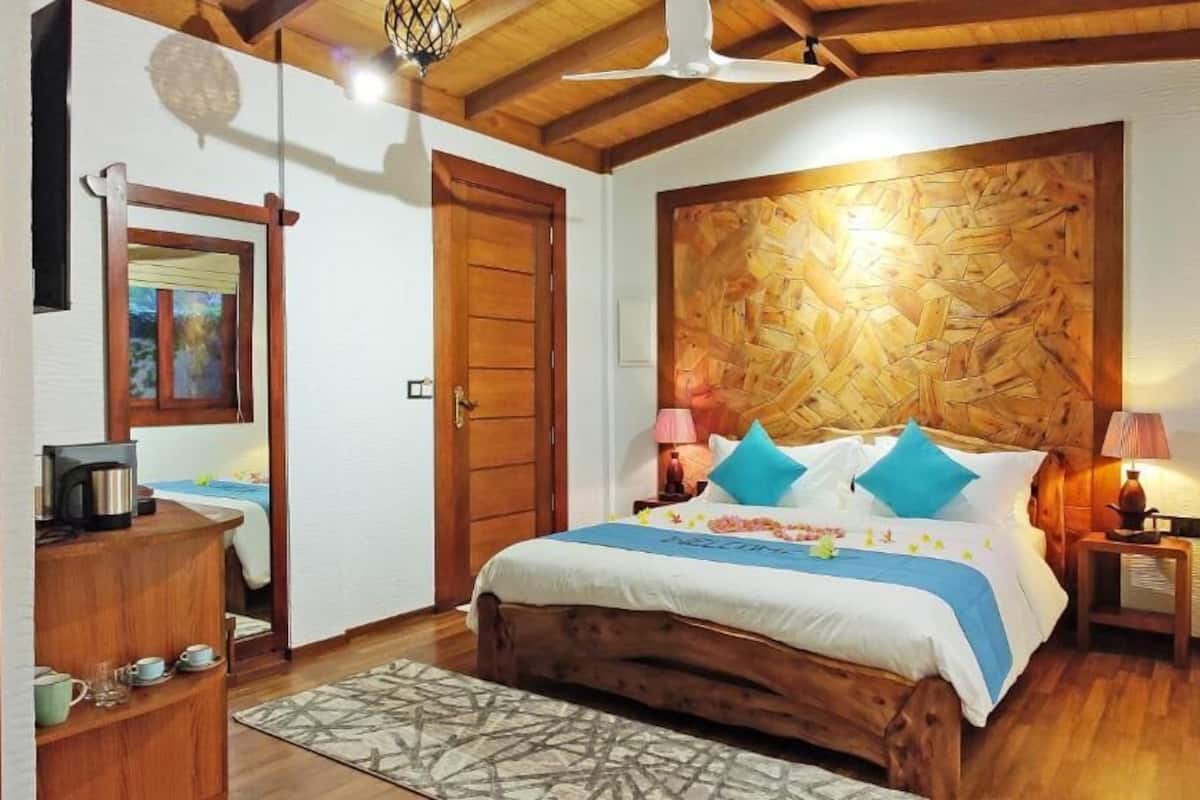 A bedroom with a wooden bed, a nightstand, a lamp, and a wooden headboard.