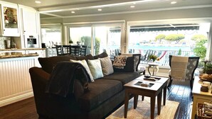 Ein Wohnzimmer mit einem dunkelbraunen Sofa, einem Couchtisch und Blick ins Freie.