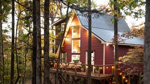 A cabin with a wooden deck and a metal roof, surrounded by trees. - Couples Tree Loft  Rock Hot Tub Buffalo River (St Joe)