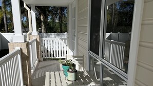 A covered porch with white railings, a potted plant, and a bench. - Hunter Valley guest house (Nulkaba)