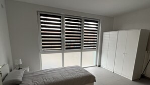 A bedroom with a bed, a wardrobe, and a window with blinds. - Apart Rom Hannover Centrum (Hannover)