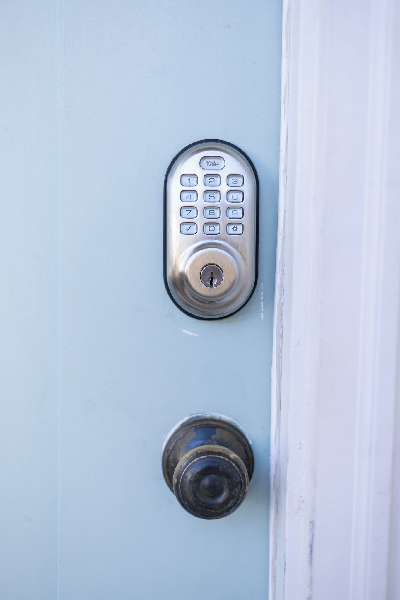 A door with a keypad lock and a keyhole.