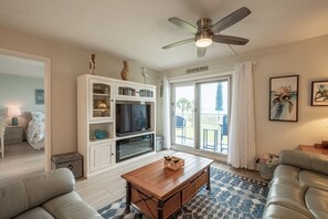 Relax in a spacious living room with a sofa, television, and ceiling fan.