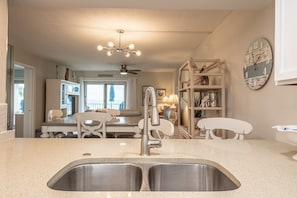 Enjoy cooking in this well-equipped kitchen with a central island and stainless steel sink.