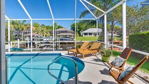 A pool area with a clear view of the surrounding neighborhood, including houses and a marina.