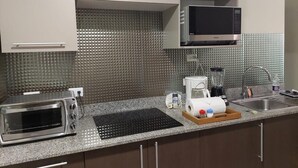 Uma cozinha com torradeira, cafeteira e micro-ondas.