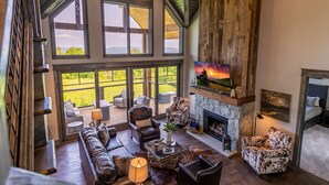 A spacious living area with a fireplace, large windows, and a cozy seating arrangement.