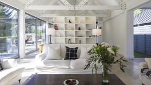 Un salon moderne avec un canapé blanc, une table basse et une bibliothèque.