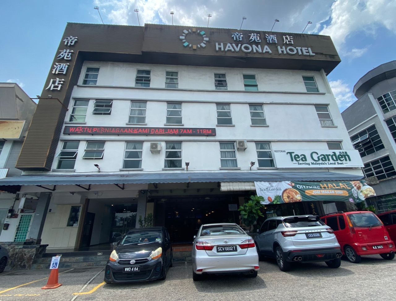 A hotel with a sign reading "HAVONA HOTEL" and a restaurant named "Tea Cardeh" with a sign for "DIY Halal Jom Makani Shih."