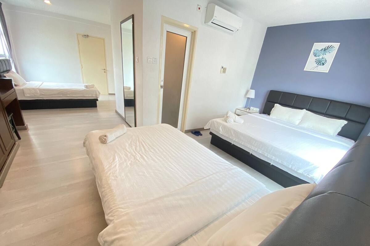 A hotel room with two beds, a bathroom, and a view of the street.