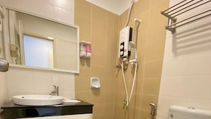 Um banheiro pequeno com pia, vaso sanitário e chuveiro.