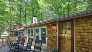 A wooden deck with outdoor seating and a glass door.