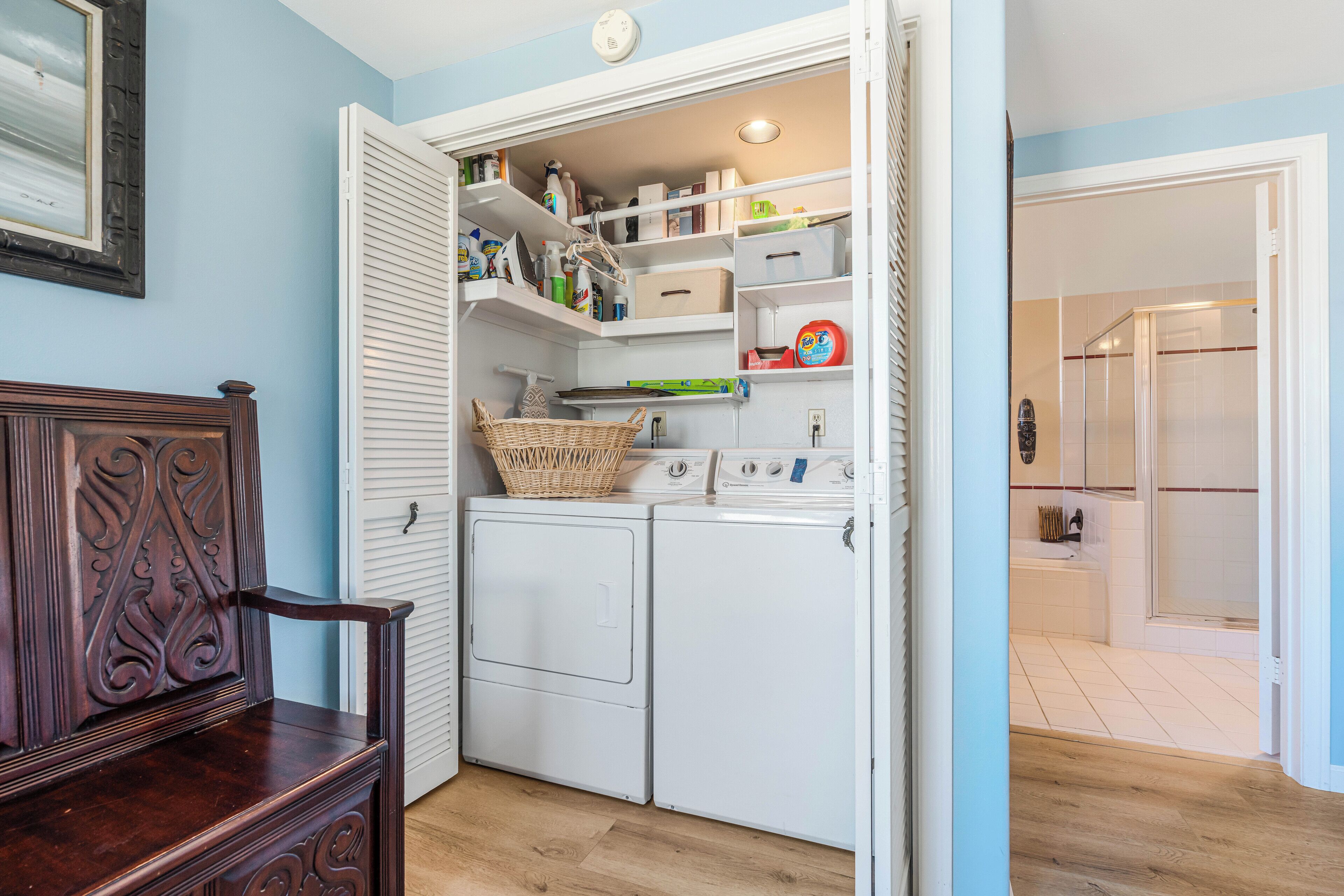 A laundry room with a wooden dresser, a washing machine, and a dryer.