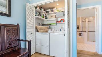 A laundry room with a wooden dresser, a washing machine, and a dryer.