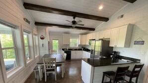 A spacious kitchen with white cabinets, a large island with bar stools, and a ceiling fan. - 4 Bedroom 3 Bath Lakefront Home with Private Dock, Secluded, Lewis Smith Lake (Double Springs)