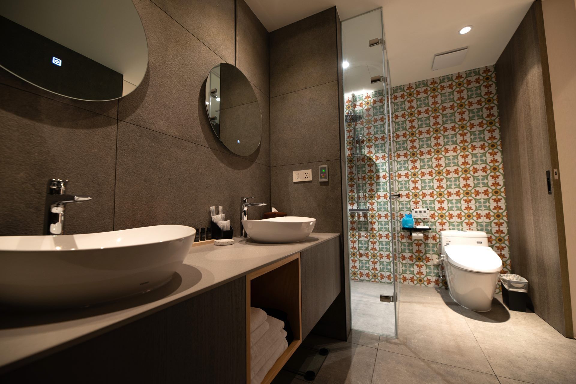 A modern bathroom with a large sink, a mirror, a toilet, and a shower area.