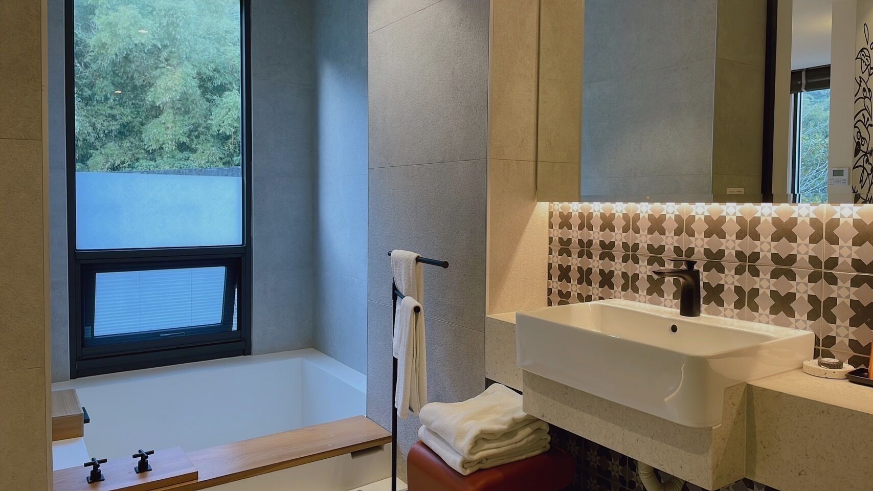Ein modernes Badezimmer mit einer Badewanne, einem Waschbecken und einem Fenster.