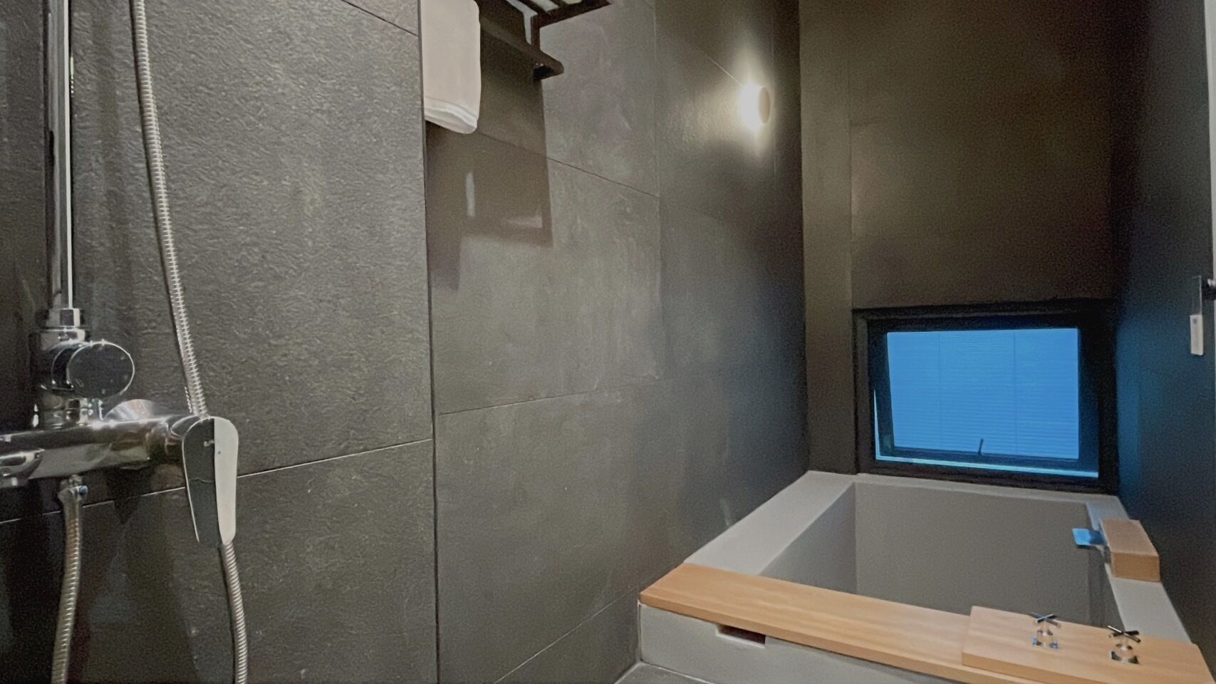 Un baño moderno con bañera, ducha y ventana.
