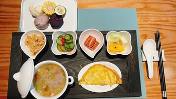 Bandeja de comida con diferentes platos, entre ellos sopa, tortilla y verduras.