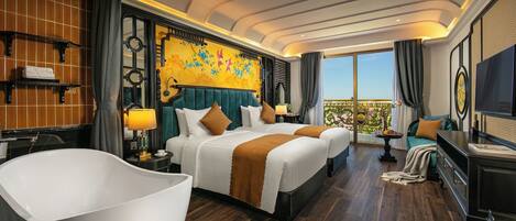Une chambre d’hôtel avec un grand lit, une baignoire, une télévision et un balcon avec vue.