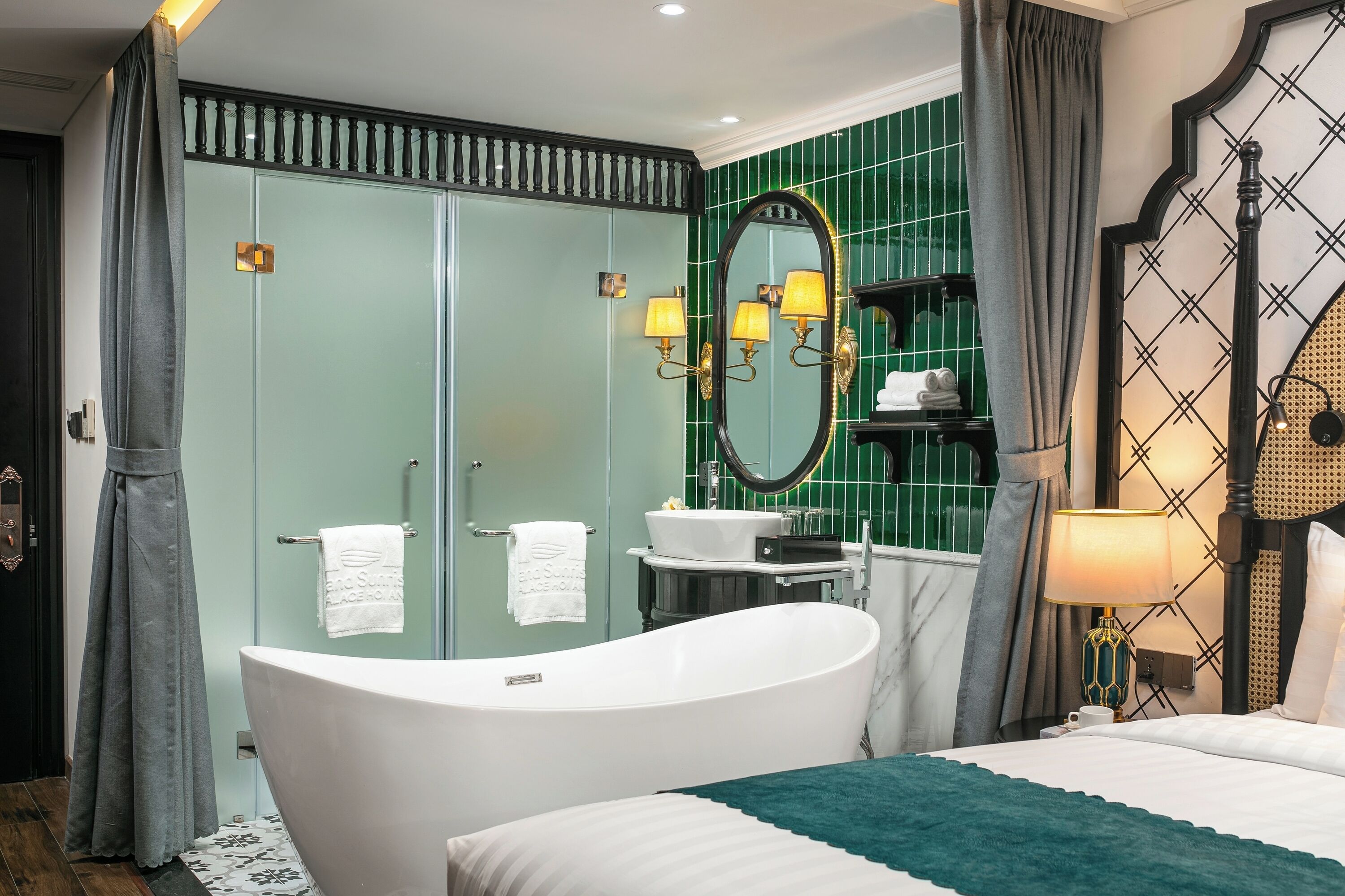 A modern bathroom with a freestanding bathtub, a large mirror, and a vanity with a sink and towel rack.