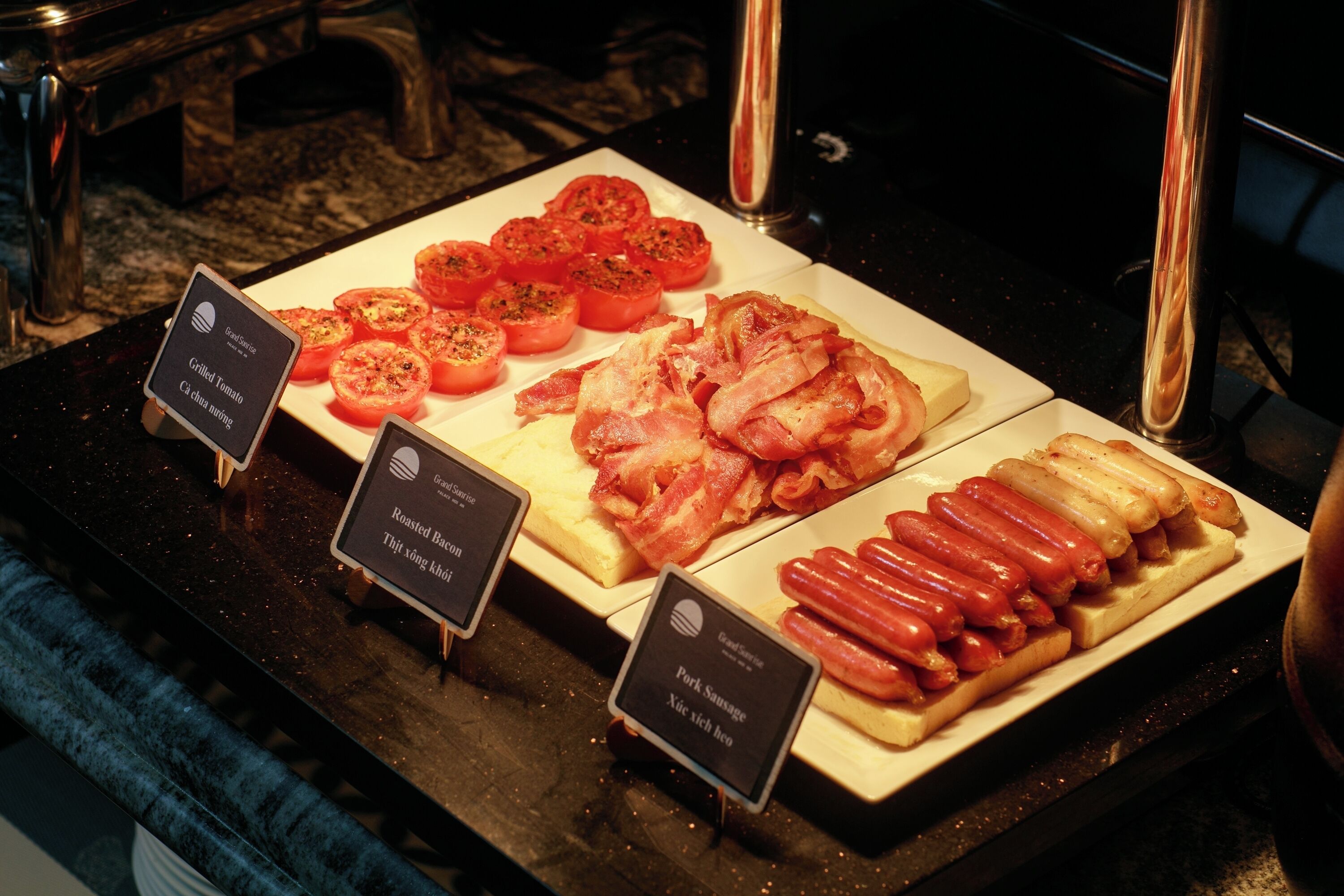 Exhibición de comida con tomates a la parrilla, tocino y salchichas.