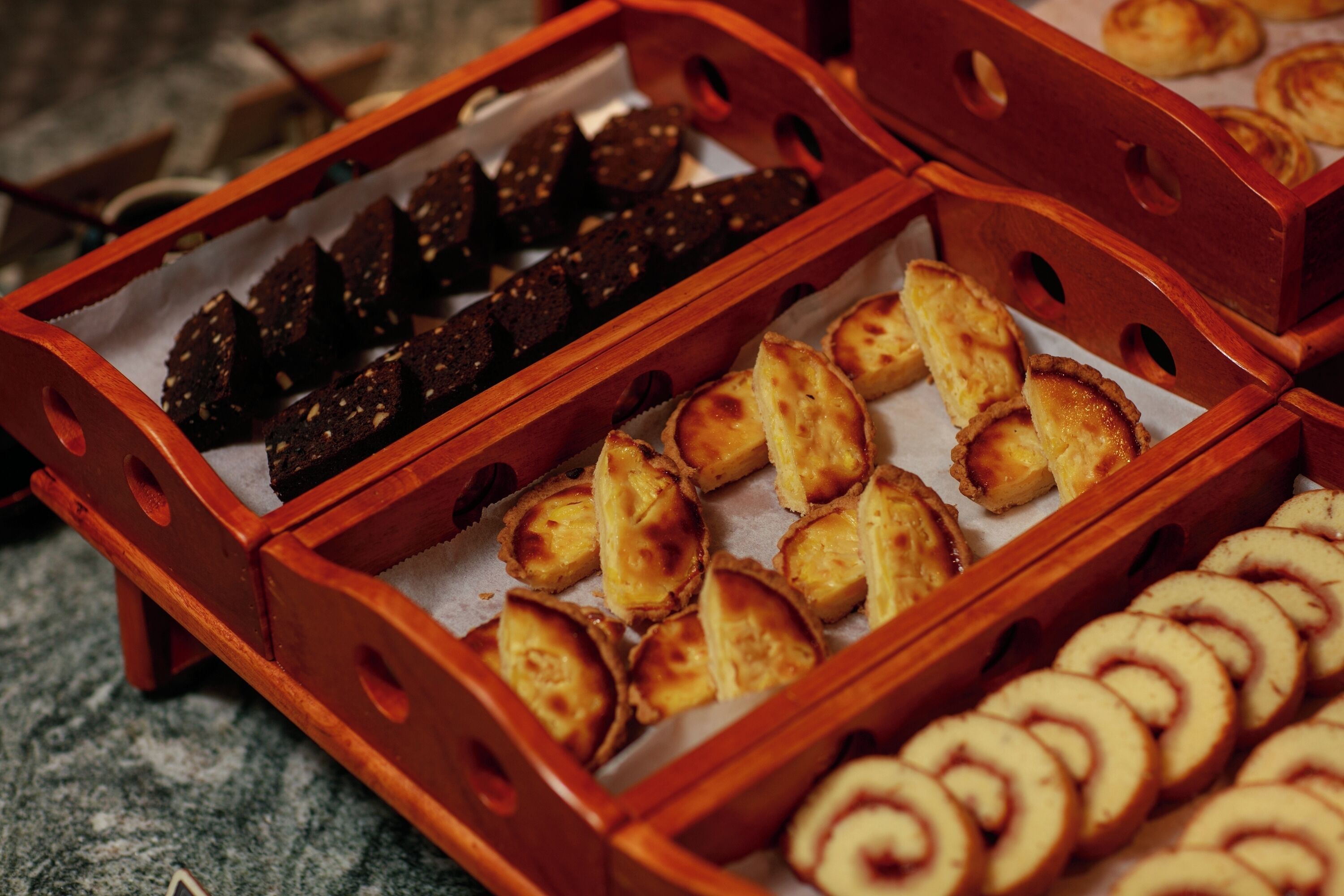 A variety of baked goods in wooden trays.