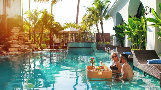 A pool area with lounge chairs and a small waterfall feature. - Grand Sunrise Palace Hoi An (Da Nang)
