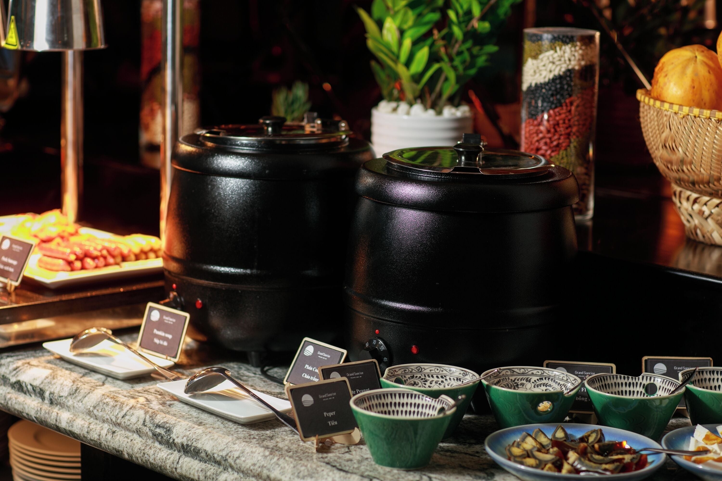 A buffet setup with various food containers and serving utensils.