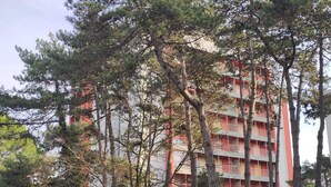 A multi-story building with balconies, surrounded by trees. - Alideco - Lignano Sabbiadoro (Lignano Sabbiadoro)
