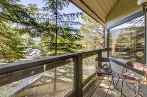 A balcony with a view of a forest and a building. - Telemark 8 - Ski in Walk out, Private Sauna, Short Walk to the Village (Whistler)