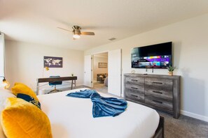 A hotel room with a bed, a desk, a television, and a wardrobe. - Endless Oasis | Pool, Spa, Game Room near Disney (Davenport)
