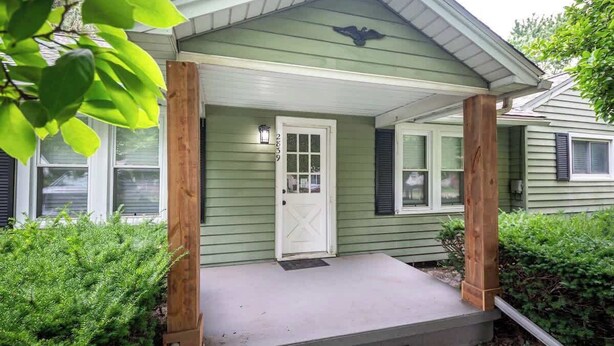 A house with a front porch, a door with a window, and a mailbox. - Simple & Sweet 2 BR 1 BA Home in Lansing - Cynwood (Lansing)