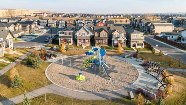 A residential area with houses, a playground, and a road. - Luxury 2 Bedroom Suite (Airdrie)