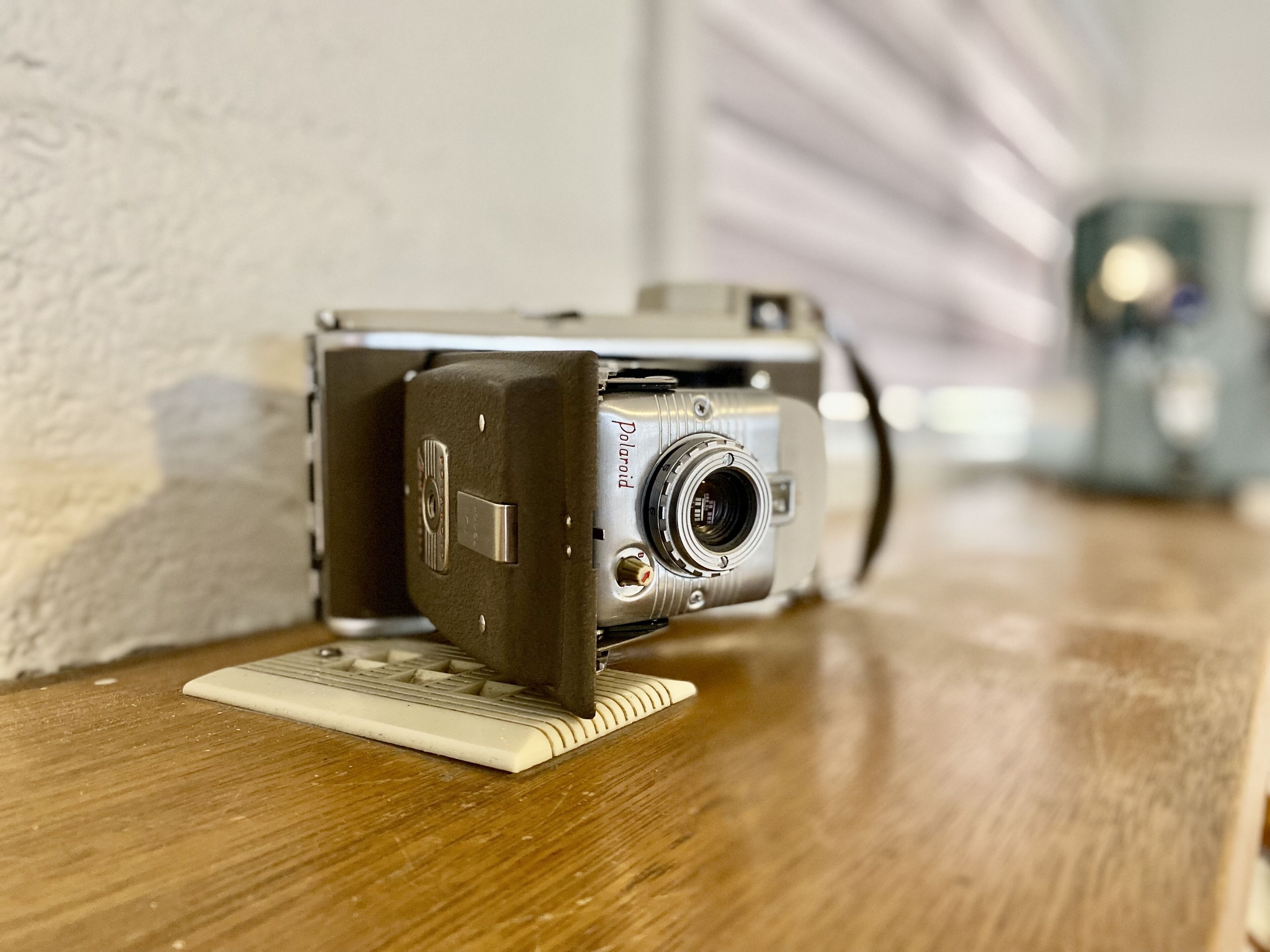 A vintage Polaroid camera on a wooden surface.