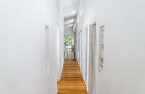 Stunning hallway with doors and glass panels, leading to a bright open space.