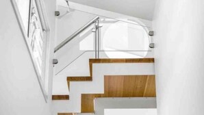 Un escalier moderne avec des rampes en verre et des marches en bois.