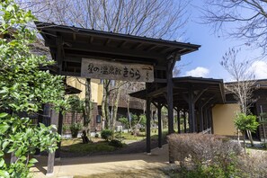 Un edificio japonés tradicional con estructura de madera y un cartel que indica una ubicación.