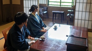 Een traditionele Japanse kamer met tatami vloerbedekking, een lage houten tafel en shoji schermen.