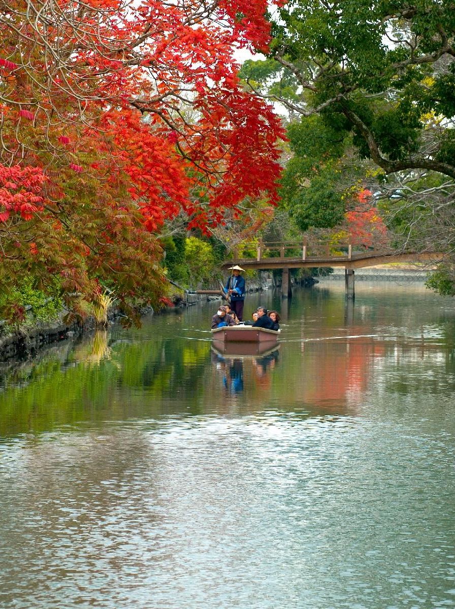 Un río tranquilo con un puente de madera y barcos.