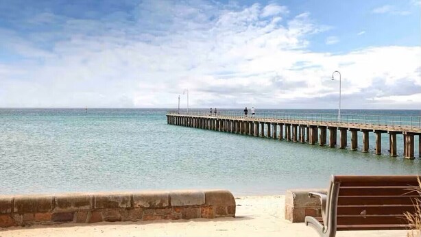 A pier extending into calm waters with a clear sky above. - Dromana Charmer - Large family home, 8 min easy walk to the beach. (Dromana)