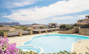 A swimming pool with stone walls and a view of mountains in the background. - A little piece of paradise... (Pittulongu)