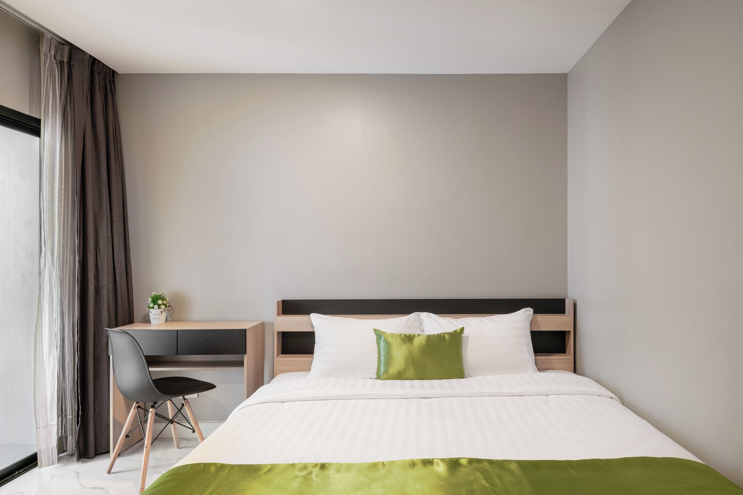 Una habitación de hotel moderna con una cama, un escritorio y una silla.