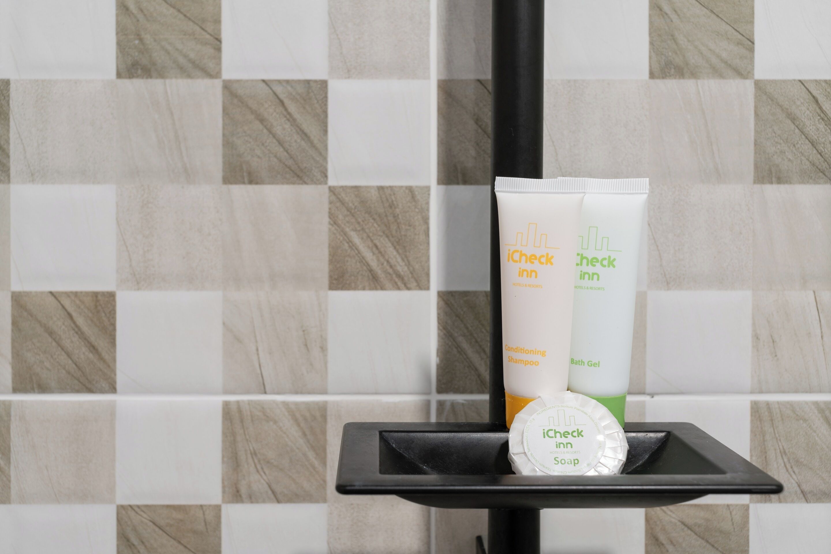 Toiletries on a black tray in a bathroom with checkered tile walls.