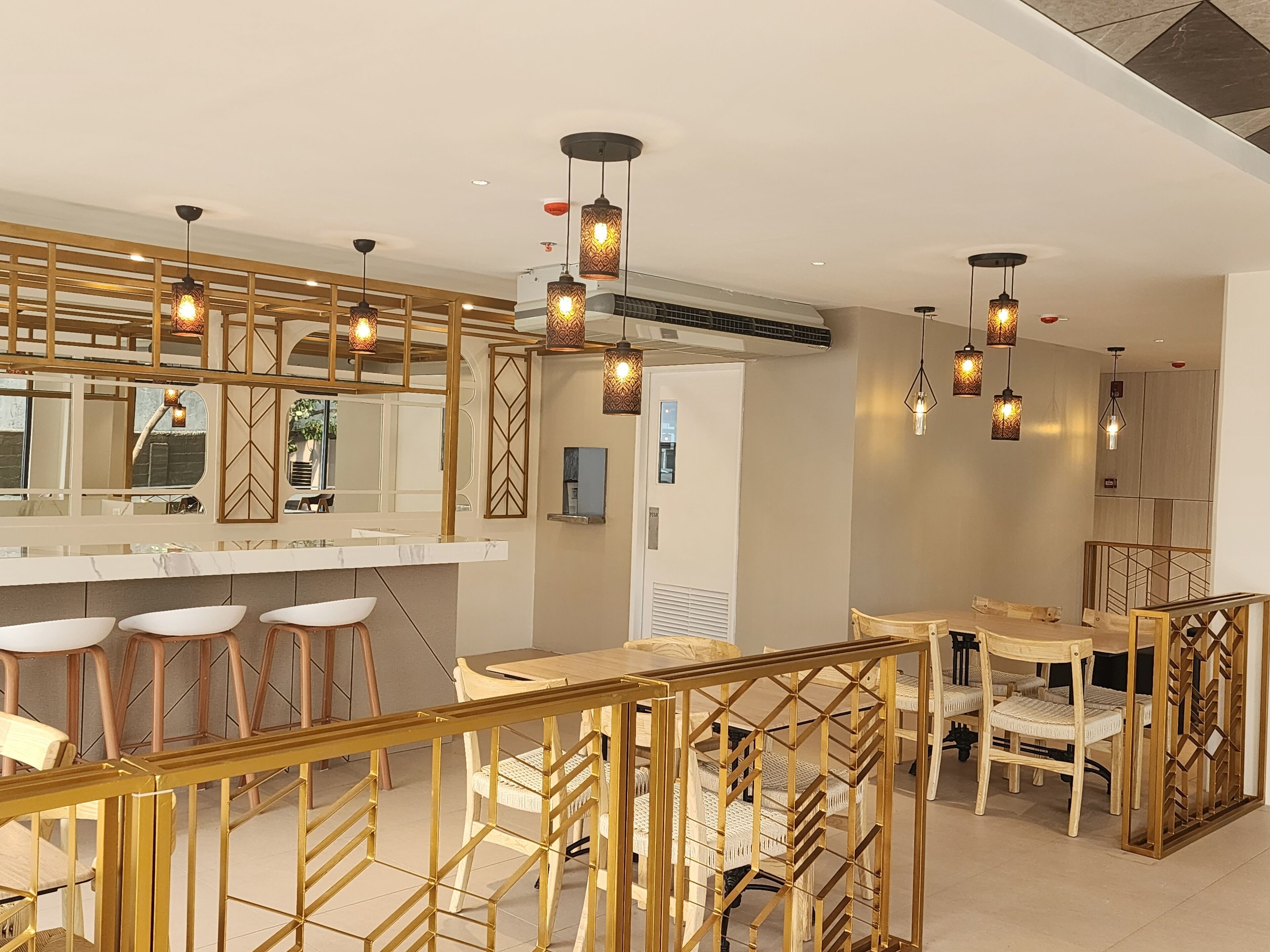 Un interior moderno con barra, asientos e iluminación decorativa.