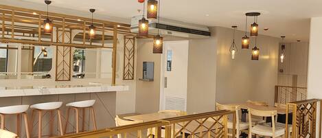 Un interior moderno con barra, asientos e iluminación decorativa.