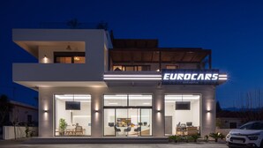 Un edificio moderno de dos pisos con un servicio de alquiler de coches llamado "Eurocars".