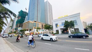 Une rue animée en plein centre-ville, bordée d’immeubles modernes de grande hauteur, dont un hôtel appelé «Westin Hotel».