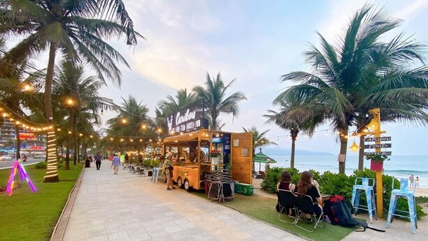 Un camion-restaurant appelé «Caribou» est installé sur une allée pavée, bordée de palmiers et dotée de chaises pour que les clients puissent s’asseoir.
